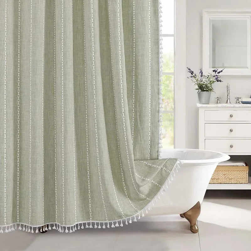 Green striped shower curtain with tassels in a bathroom setting
