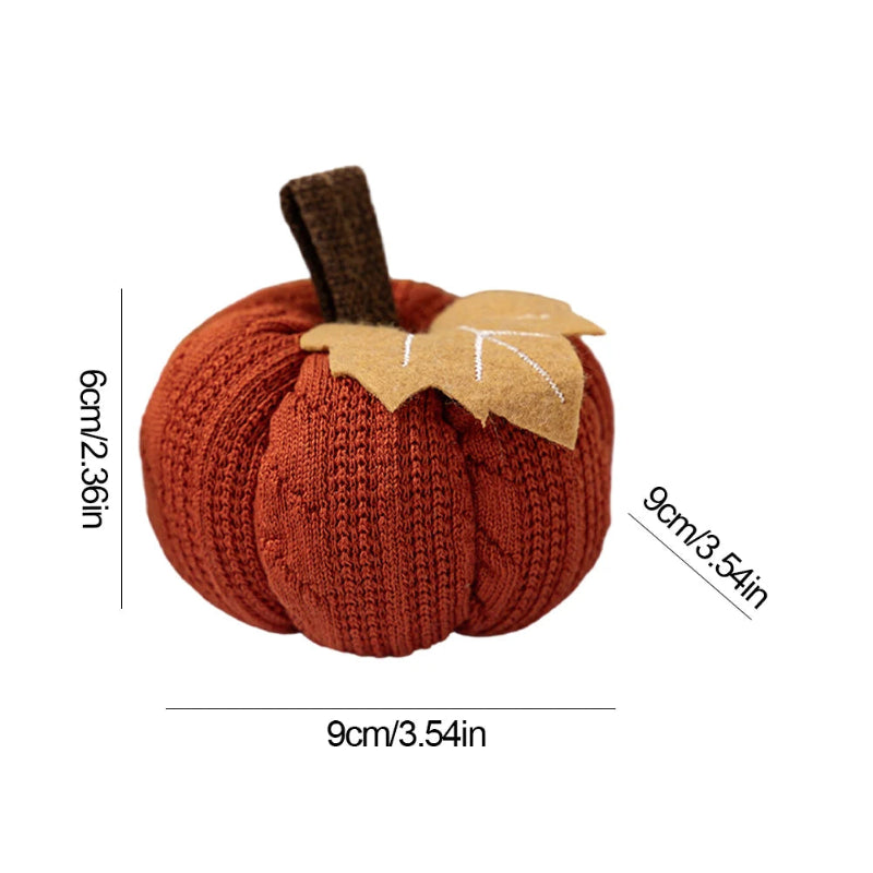 An orange knitted pumpkin with a brown stem and a beige felt leaf is shown with dimensions of 9cm (3.54in) in width and depth, and 6cm (2.36in) in height, on a white background.