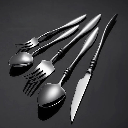 A set of six dark silver utensils on a black background.