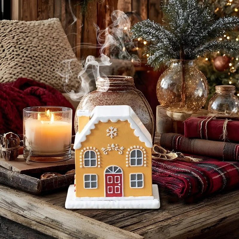 Decorative gingerbread house candle on a wooden surface with a cozy background.