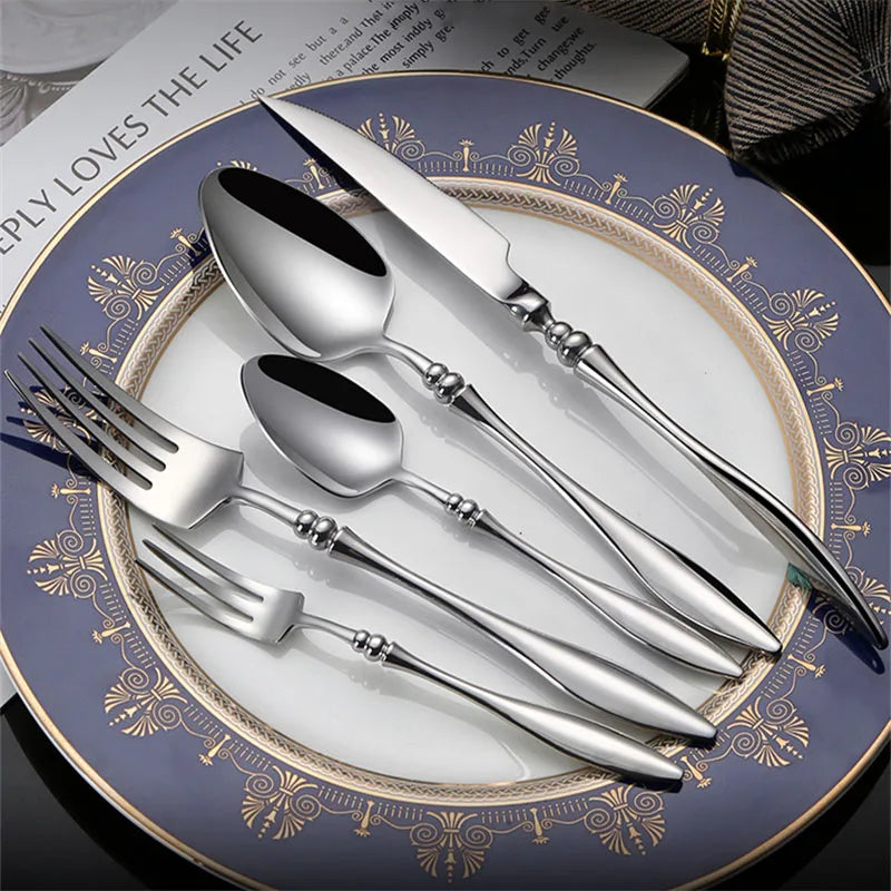 A full set of silver utensils on a decorative plate.