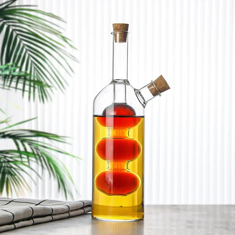 Glass bottle with cork stoppers containing layered liquids on a light surface with a plant in the background
