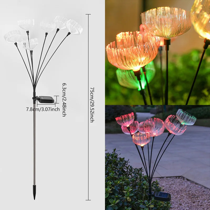 A composite image shows a diagram with dimensions of a solar-powered garden light cluster with multiple jellyfish-like fiber optic tops on flexible stems, attached to a solar panel and a stake. The total height is 75 cm/29.52 inches. The diagram also details the solar panel dimensions as 6.3 cm/2.48 inches by 7.8 cm/3.07 inches. Two inset images show the lights illuminated in a garden at night, emitting warm orange and green glows in one and pink and teal glows in the other.