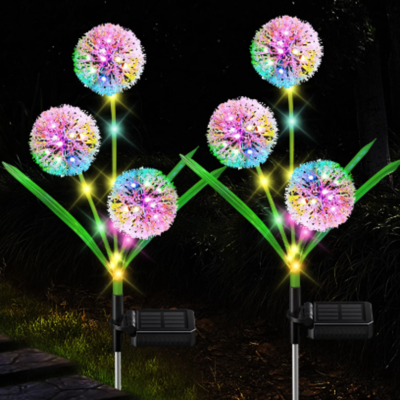 Six solar-powered dandelion garden lights glow with multiple colors in a dark garden setting.