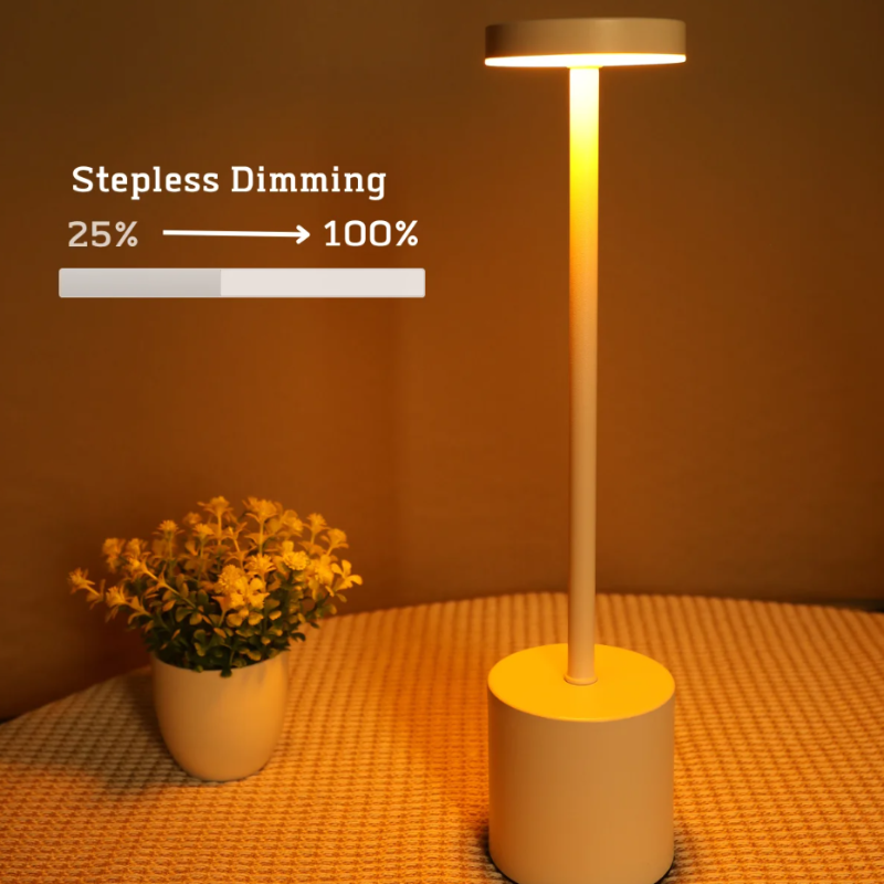 A cordless LED table lamp with a white cylindrical base, a slender stem, and a circular light panel emitting a warm glow, demonstrating its "Stepless Dimming" feature with a graphic showing a light bar increasing from "25%" to "100%." The lamp is placed on a textured orange surface next to a small white pot containing artificial yellow flowers. The background is a solid orange.