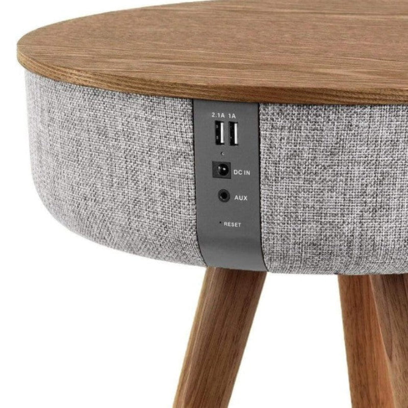 Round wooden table with gray fabric side and electronic ports on a white background