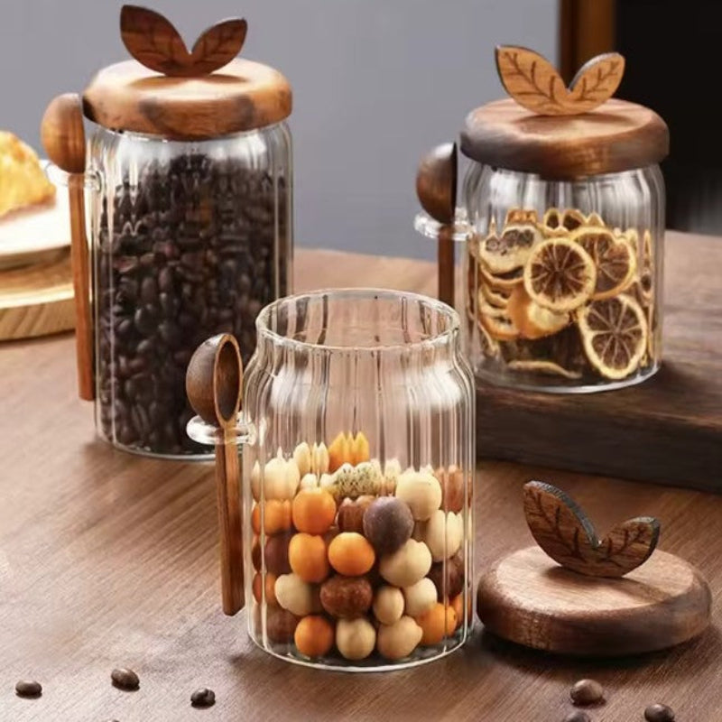 Set of glass jars with wooden lids on a wooden surface