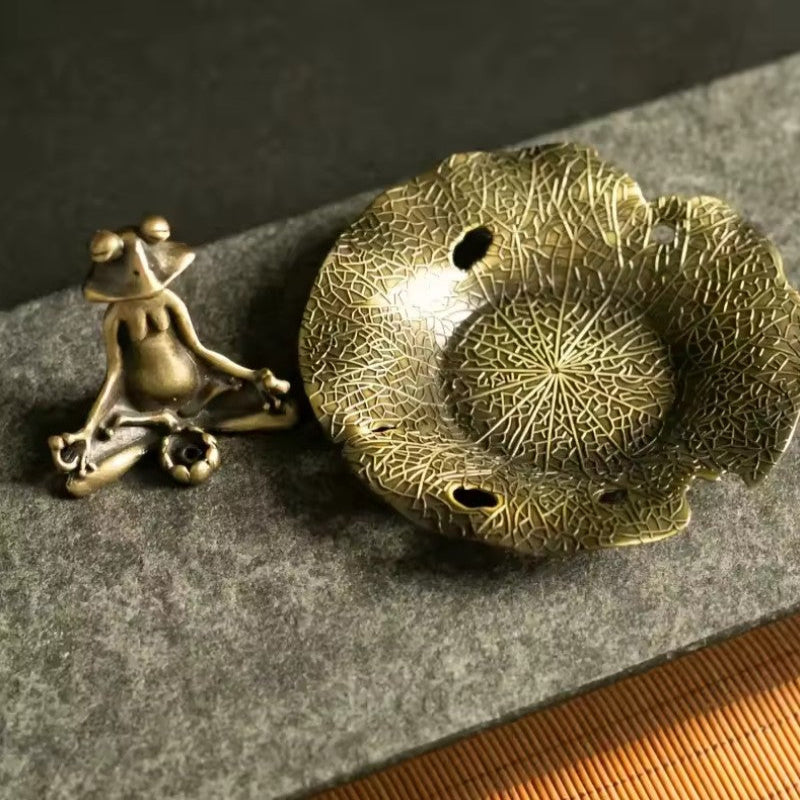 Bronze frog and lotus flower on a textured surface