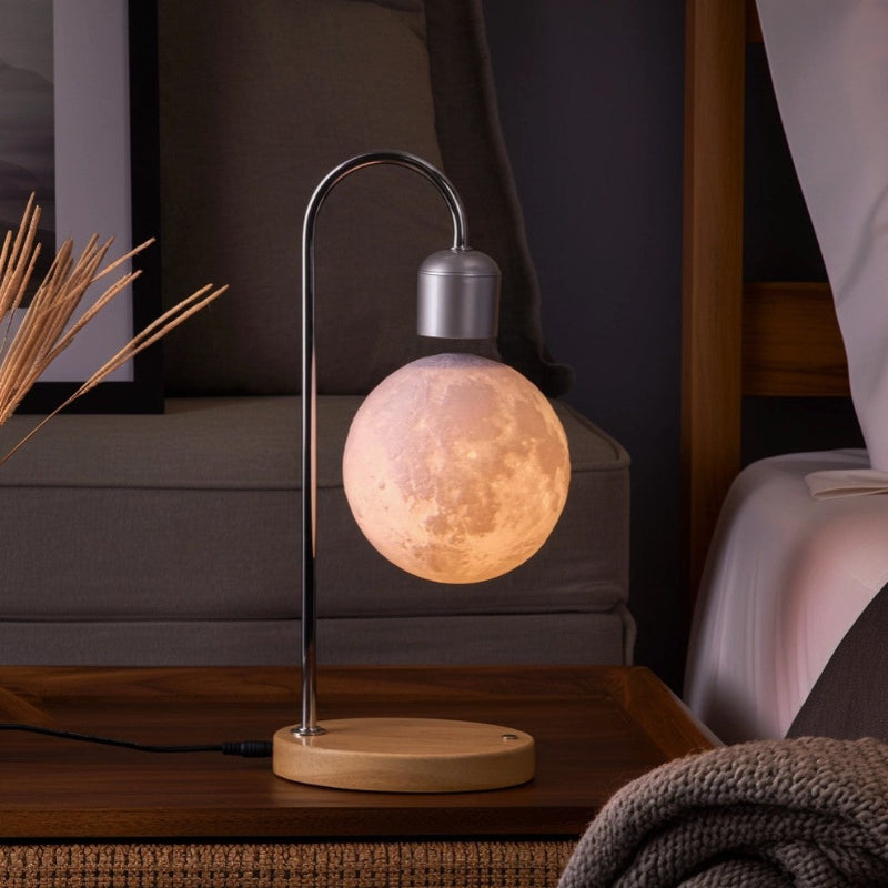 Table lamp with a moon-shaped bulb on a wooden base in a cozy room setting.