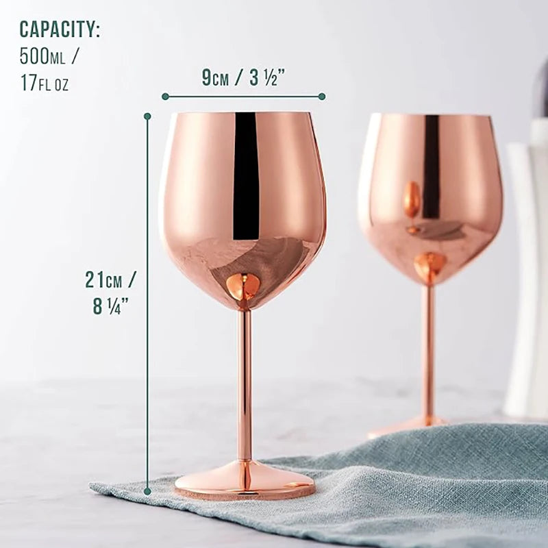 An advertisement-style shot of two copper-colored, stainless steel wine glasses, partially on a muted teal textured tablecloth with capacity, diameter, and height dimensions marked for the close-up glass. The capacity is marked at 500ml / 17 fl oz, the diameter is 9cm / 3½", and the height is 21cm / 8¼". Background is light and neutral.