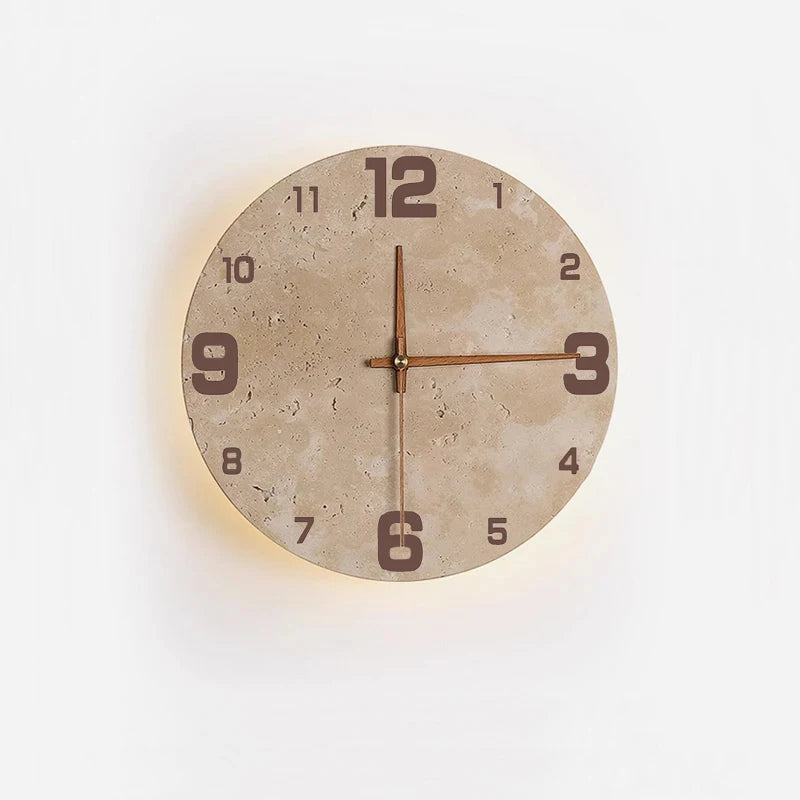 A round wall clock with a light-colored, textured stone face and simple brown hands is mounted on a white wall. The clock is softly backlit, creating a subtle warm glow around its edge.