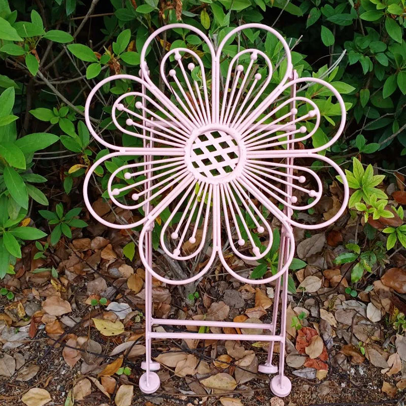 Pink metal garden chair with floral design on a natural background