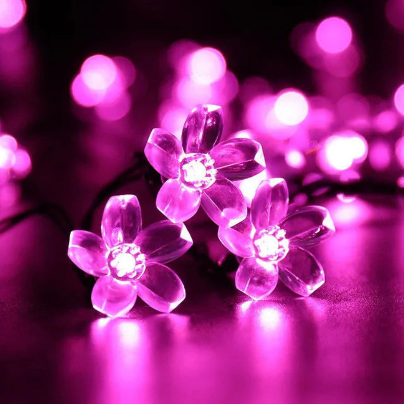 Close-up of three bright pink LED flower lights with bokeh background.