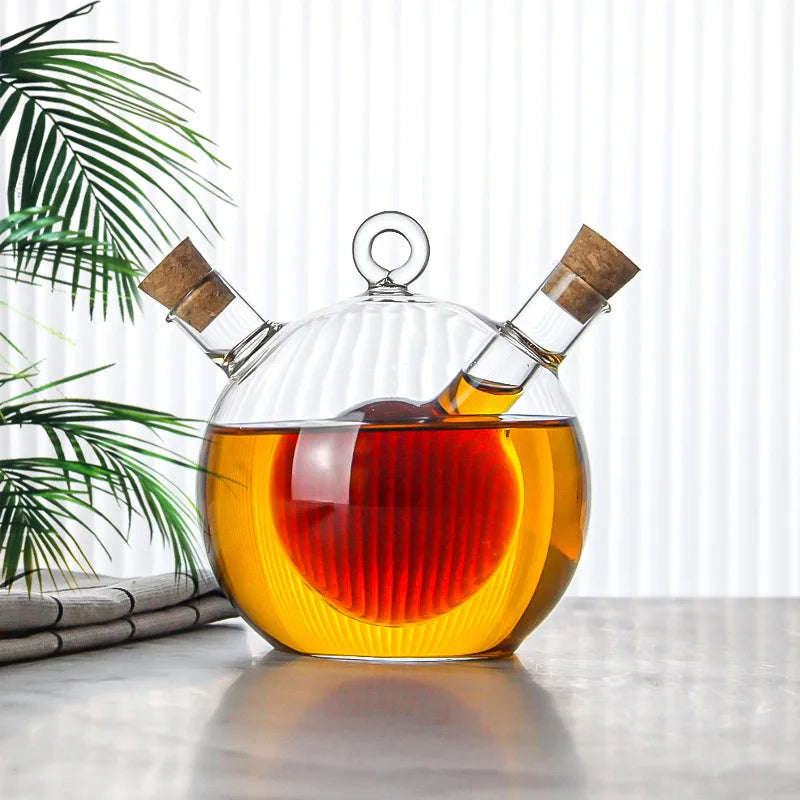 Glass decanter with cork stoppers containing a liquid, placed on a surface with a plant in the background.