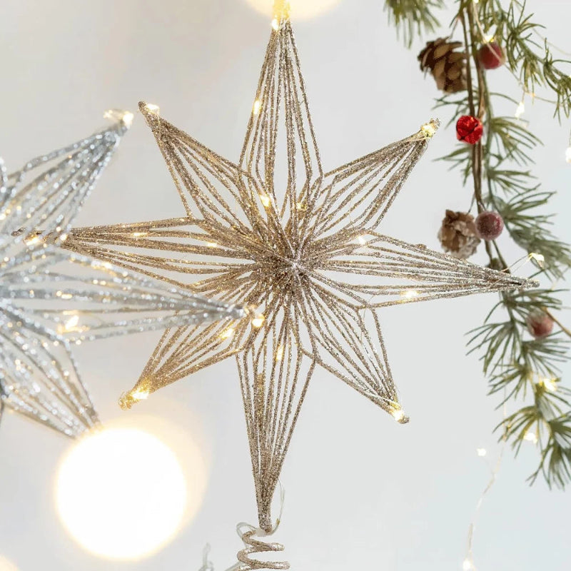 Close-up of a gold illuminated glitter wire star Christmas tree topper.