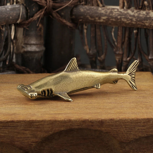 Bronze shark figurine on a wooden surface with a rustic background