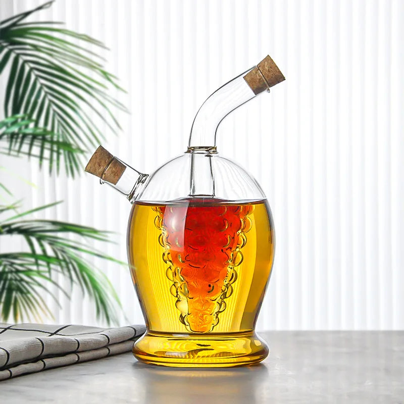 Glass decanter with cork stopper filled with amber liquid on a table with a plant in the background
