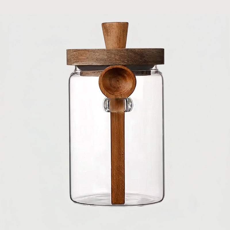 Tall airtight glass jar with acacia lid and spoon on white background