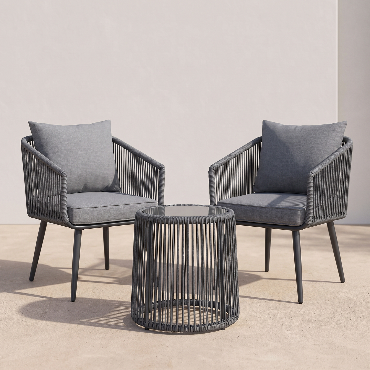 Two gray chairs with cushions and a matching round table on a neutral background
