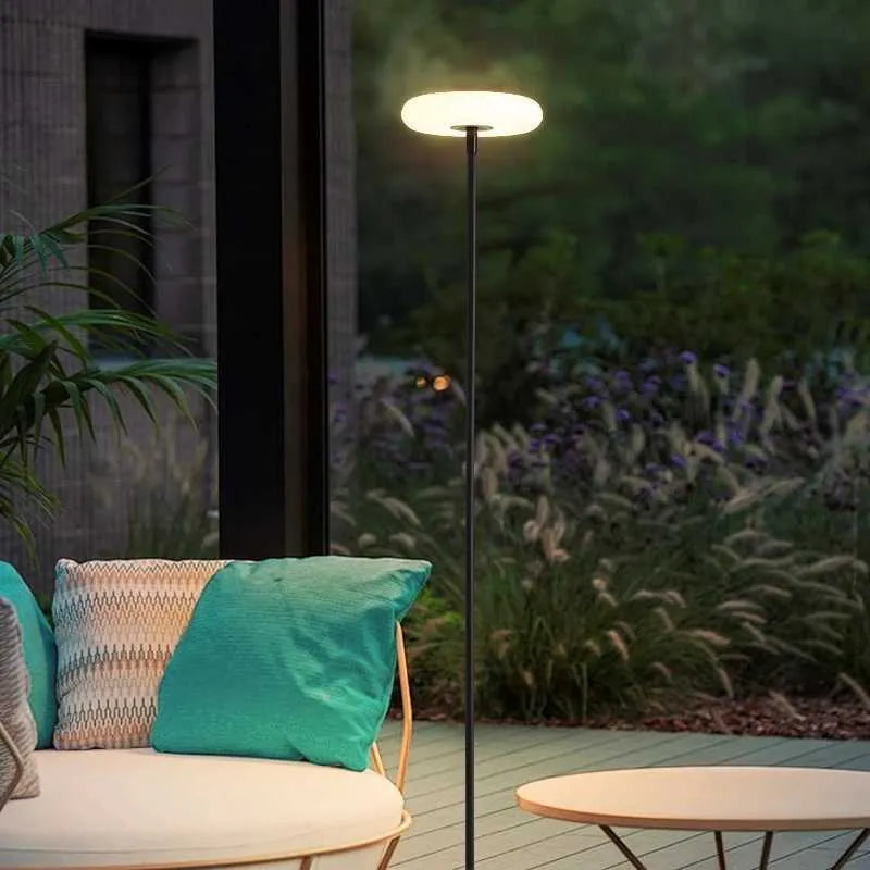 Outdoor setting with a lamp, sofa, and garden at night