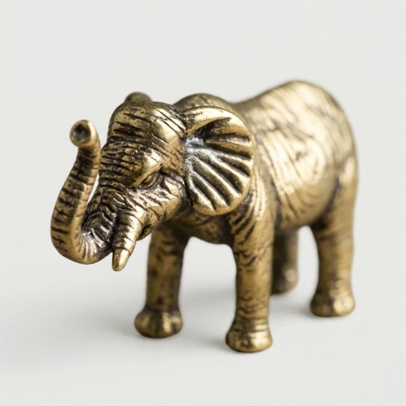 Brass elephant figurine on white background