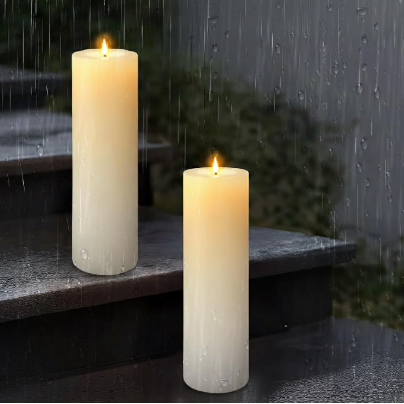 Two waterproof LED pillar candles with glowing faux flames sit on wet stone steps during a rainy night.