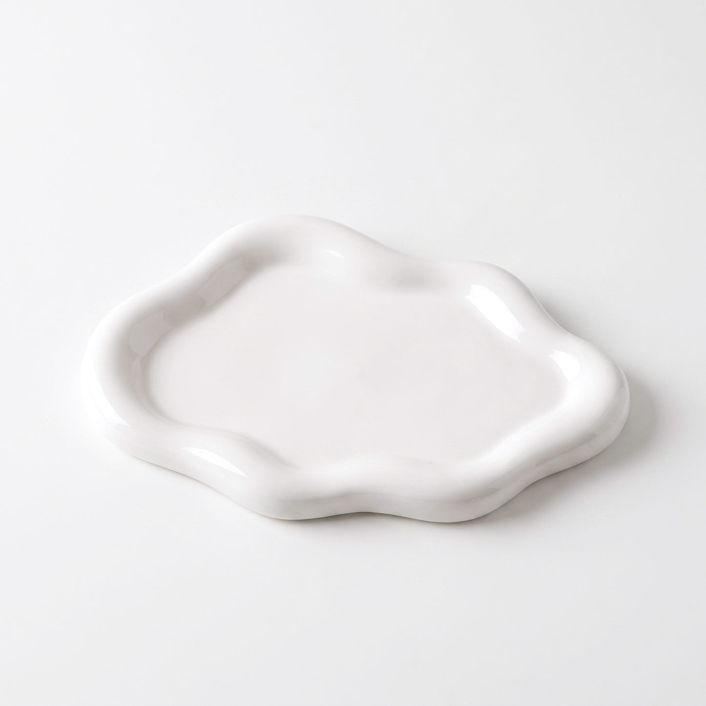 White ceramic cloud-shaped jewelry catchall on an off-white background