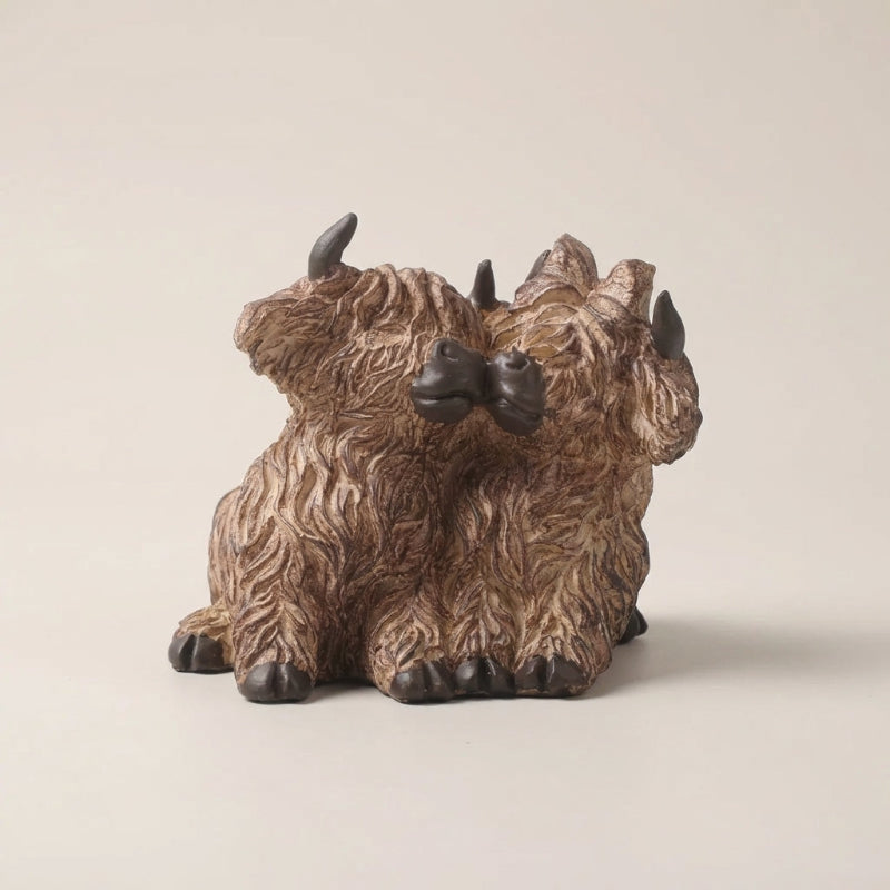 Bronze-colored triceratops dinosaur figurine on a beige background