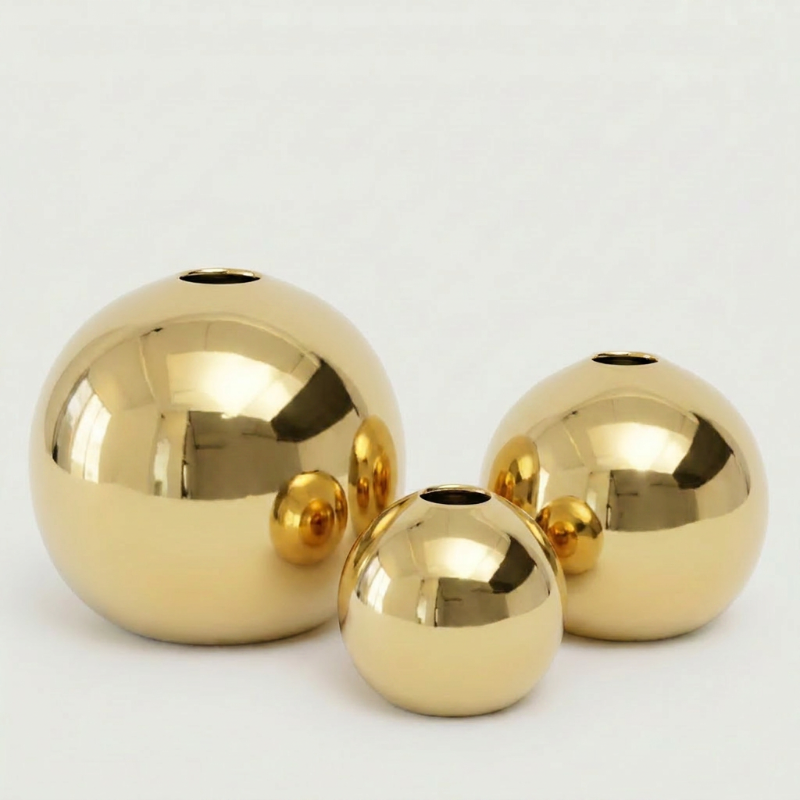 Round gold vases shown in three sizes on white background