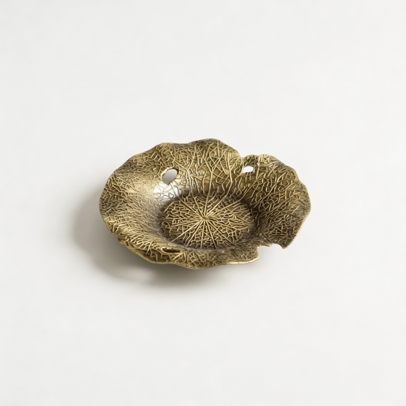 Lotus flower incense dish in antique brass finish on white background