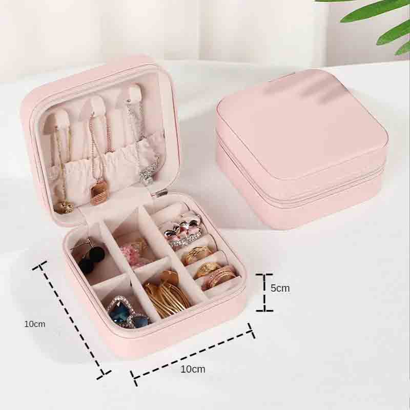 An open pink square jewelry box filled with various necklaces, earrings, and rings, with a closed matching box in the background, showing dimensions of 10cm x 10cm x 5cm.