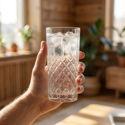 Hand holding an 11oz faceted highball glass filled with a cocktail