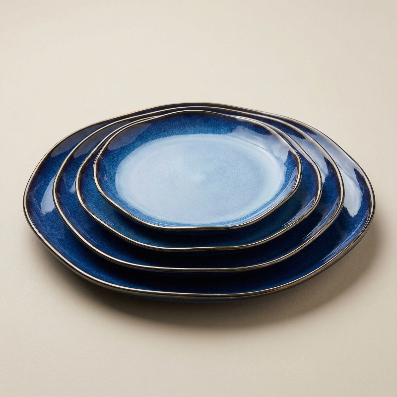 Set of blue ceramic plates stacked on a beige background