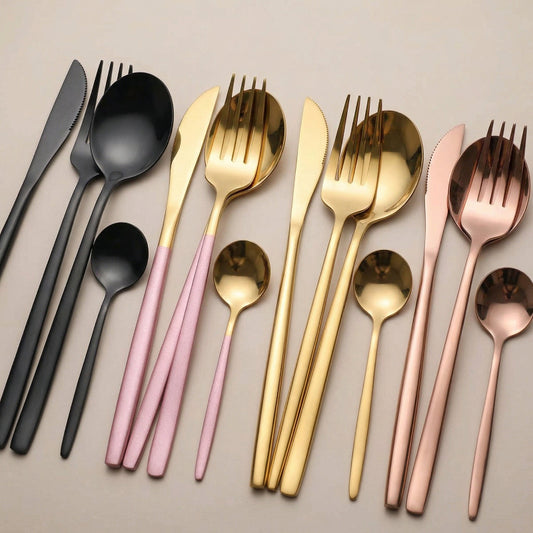 Set of black, pink, gold, and rose gold flatware on a beige background