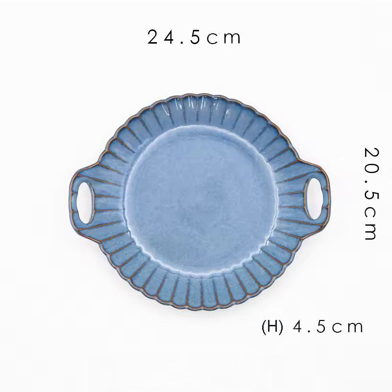A round blue ceramic serving plate with handles.