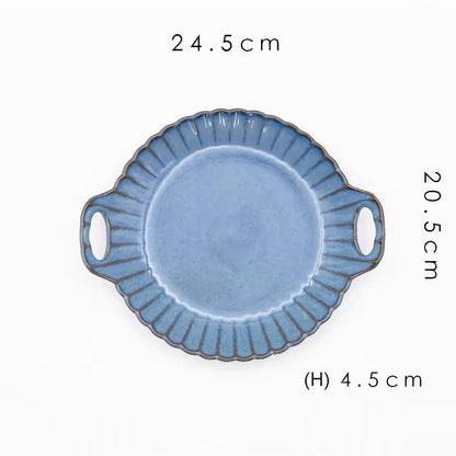 A round blue ceramic serving plate with handles.
