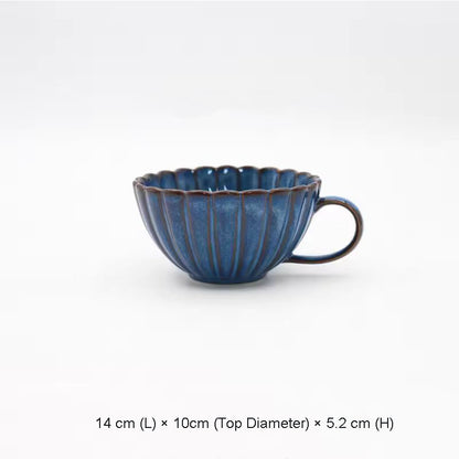 A blue ceramic teacup with a scalloped rim and vertical ridges.
