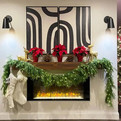 Decorative Christmas mantel with garlands, poinsettias, and stockings against a wall with abstract black and white design.