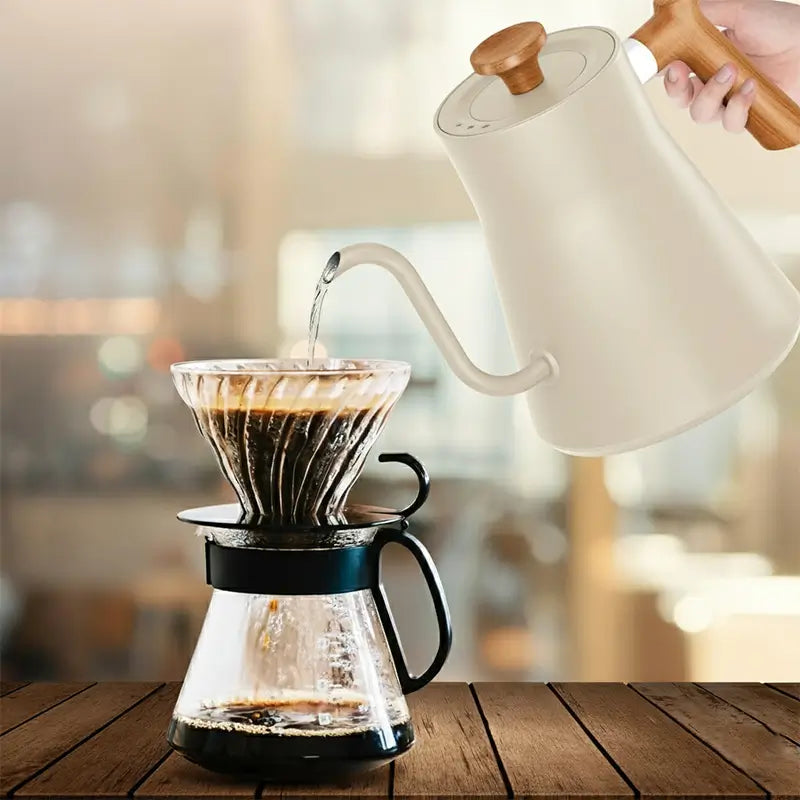 Kettle pouring water into coffee dripper.