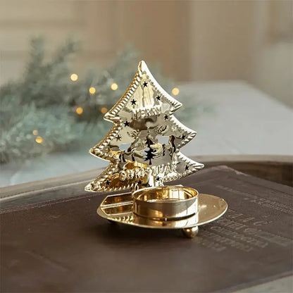 A single golden Christmas tree-shaped tea light holder sitting on a dark book.