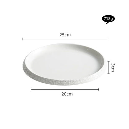 A modern white porcelain plate with a textured stone-patterned edge, measuring 25 cm in diameter and 3 cm in height. The plate has a sleek, minimalist design, perfect for serving meals in a stylish and contemporary dining setup.