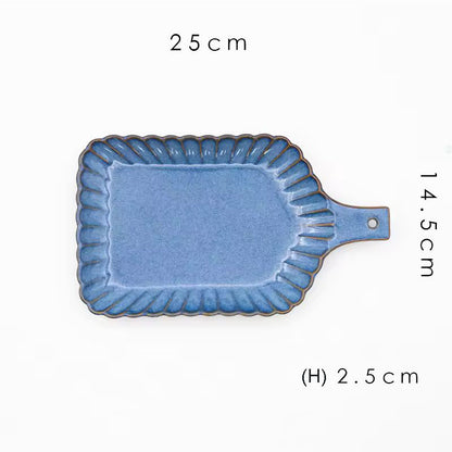 A rectangular blue ceramic serving board with a handle.