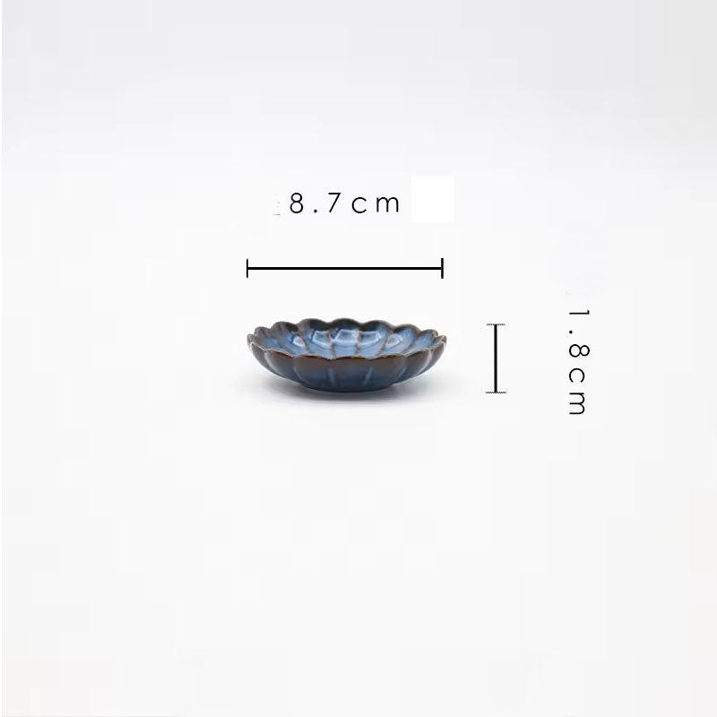 A small, blue, scalloped ceramic dish.