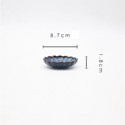 A small, blue, scalloped ceramic dish.