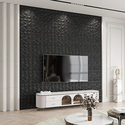 A modern living room with a black geometric textured accent wall, a mounted TV, a white media console, and a round coffee table with flowers.