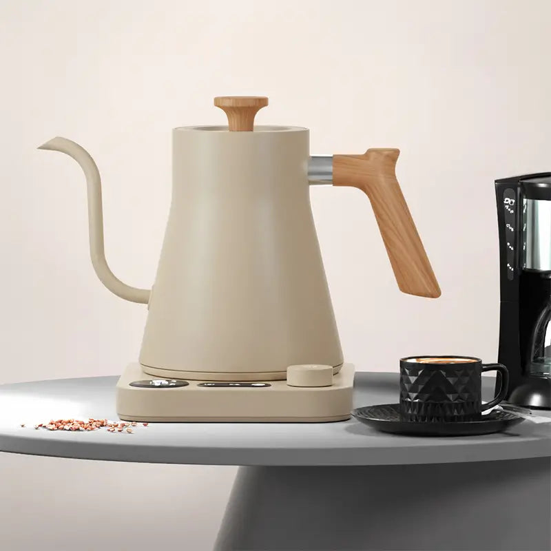 A cream-colored gooseneck kettle and a black cup of coffee.