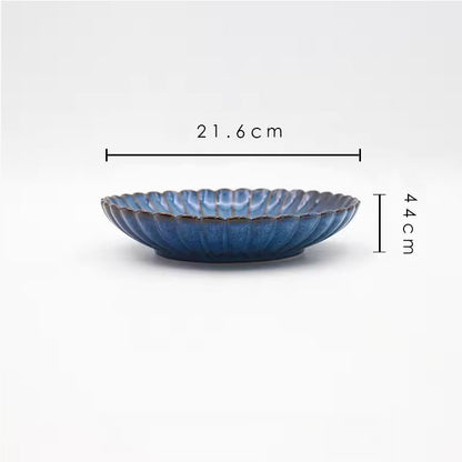 A blue ceramic plate with its dimensions labeled as 21.6 cm wide and 4.4 cm tall.