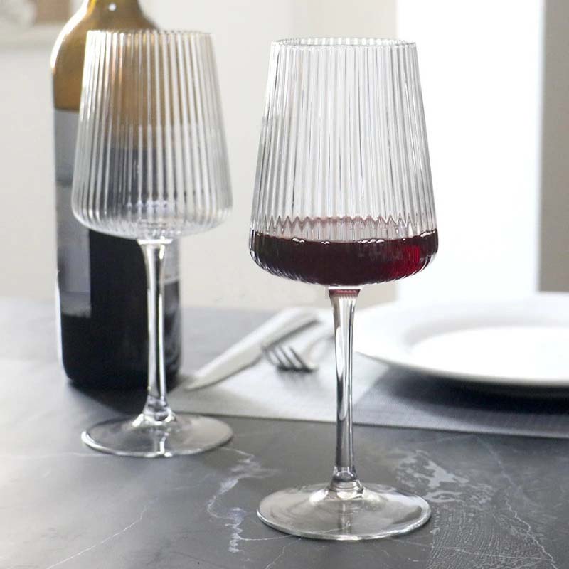 Two glasses of red wine on a table.
