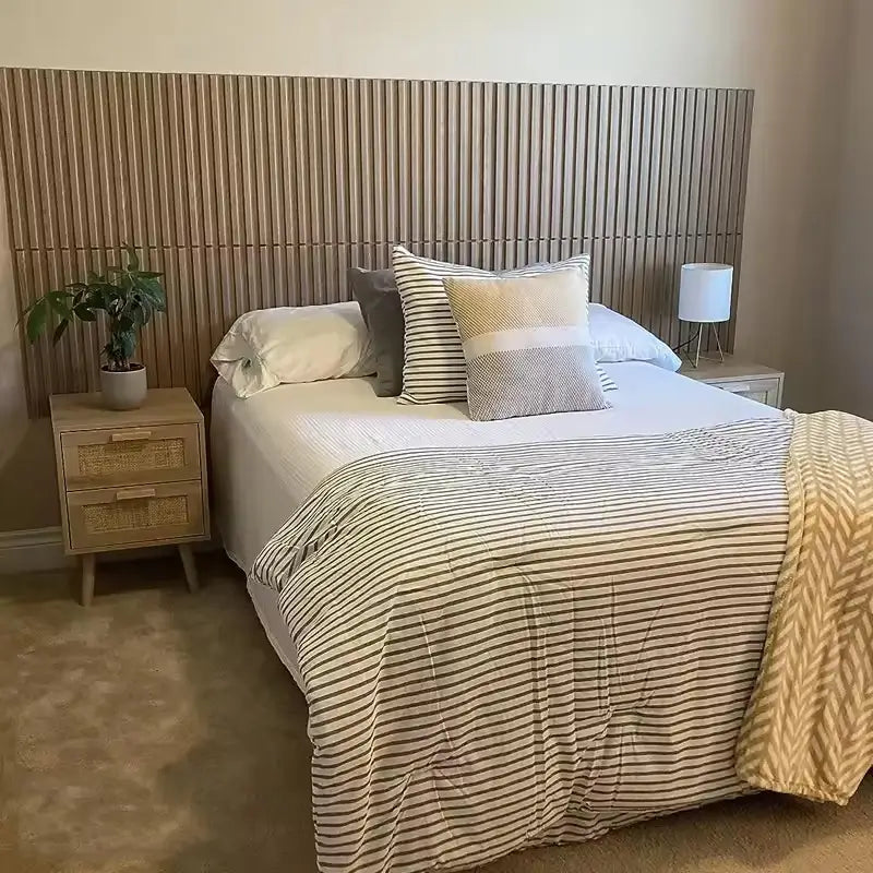 Bedroom featuring a wooden slatted headboard above a bed with striped bedding and two nightstands.