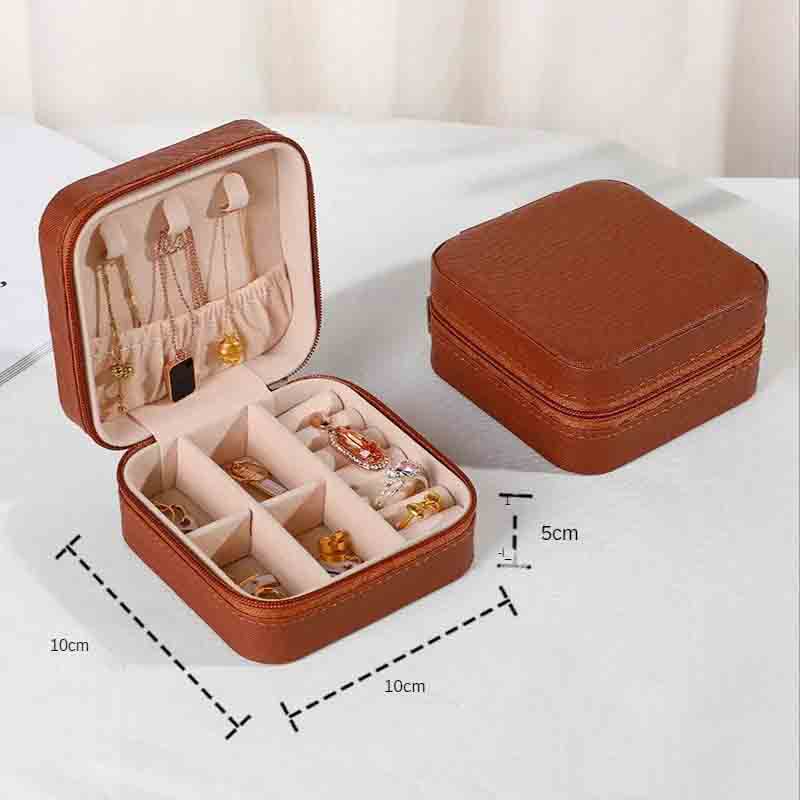 An open brown square jewelry box filled with various necklaces, earrings, and rings, with a closed matching box in the background, showing dimensions of 10cm x 10cm x 5cm.